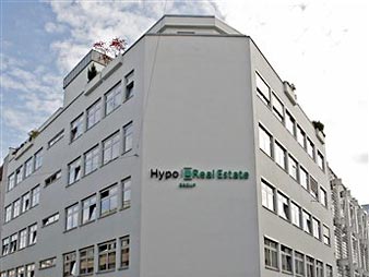 Das Logo der Hypo Real Estate spiegelt sich am Hauptsitz des Unternehmens in München auf einem Autodach.