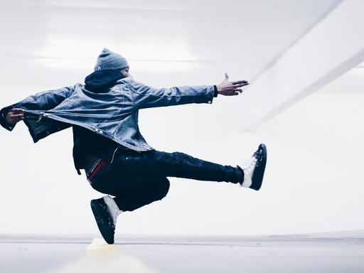 Ein junger Mann in selbstbewusster Pose bei einem Sprung.