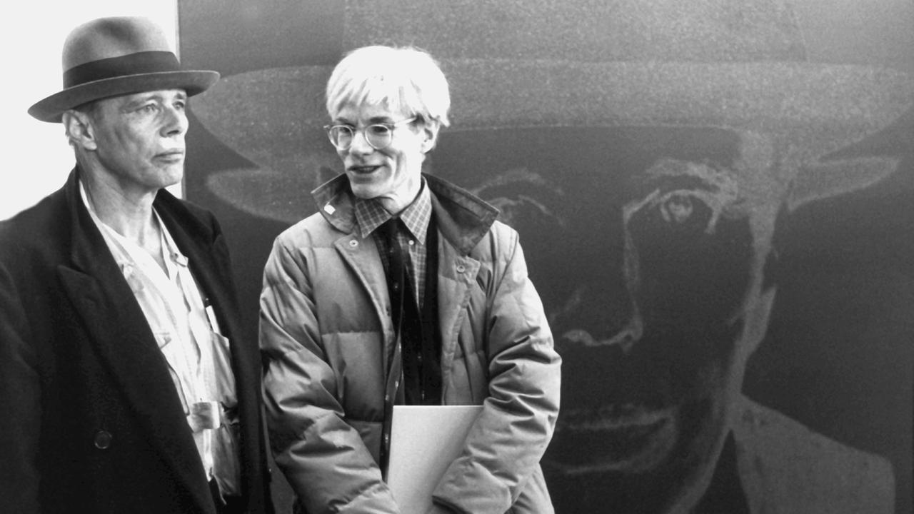 Andy Warhol (rechts) und Joseph Beuys (links), aufgenommen am 3. März 1982 in der Berliner Nationalgalerie vor dem Bild "Porträt Joseph Beuys" von Warhol