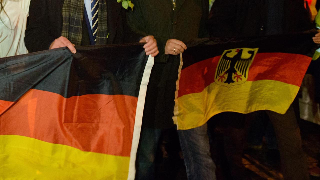 Mitglieder und Anhänger der AfD mit Deutschlandfahnen bei einer Demonstration