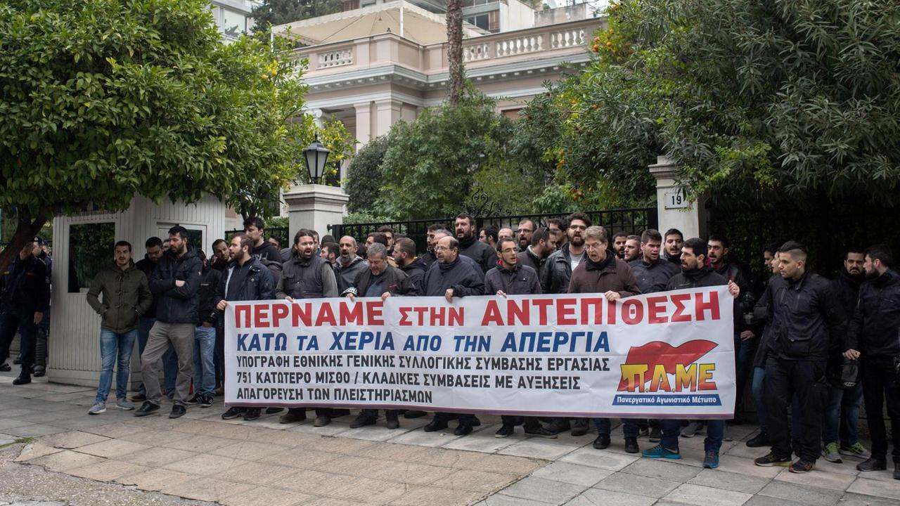 Mitglieder der kommunistischen Gewerkschaft PAME halten bei einer Demonstration am 10.01.2018 in Athen (Griechenland) ein Banner mit der Aufschrift: «Wir gehen in die Offensive. Hände weg vom Streik» während Polizisten daneben stehen. Demonstriert wird gegen geplante Änderungen des Streikrechts.