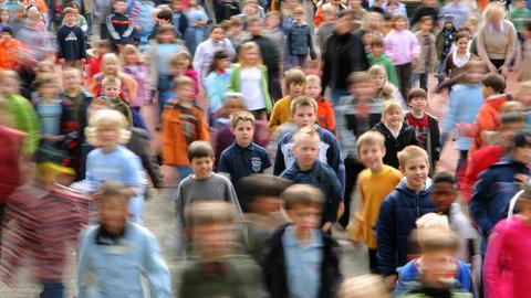 Viele Grundschülerinnen und Grundschule tanzen auf einem Schulhof.