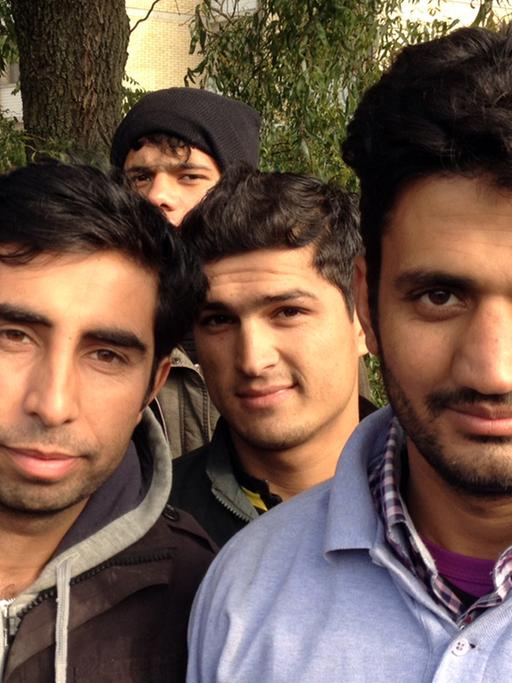 Mansur Jermal (24, l.) und Khamran Han (21), umringt von anderen jungen Männern, mit denen sie aus Afghanistan geflüchtet sind.