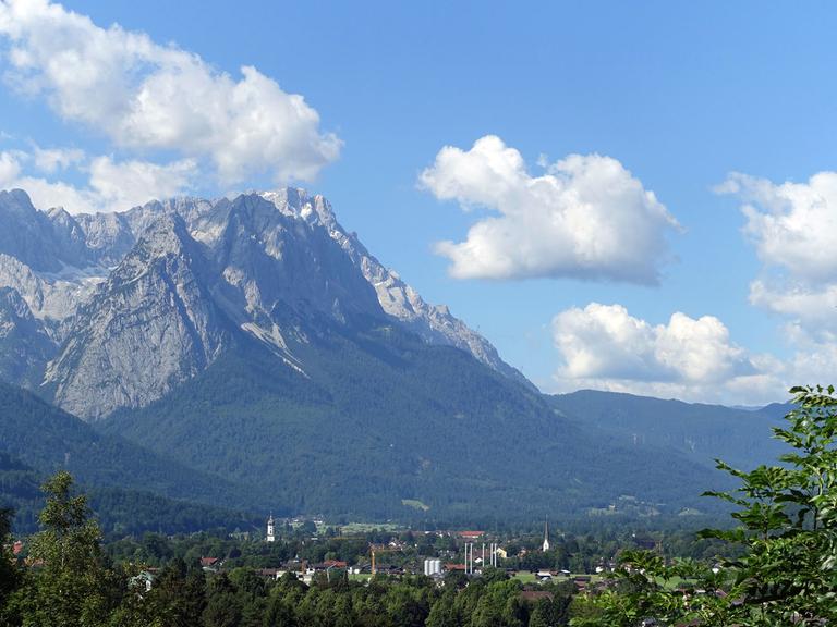 Blick auf das Wettersteingebirge mit der Zugspitze und Garmisch-Partenkirchen im Tal, aufgenommen vom Berg Wank aus.