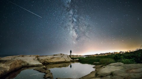 "Sternzeit" im Deutschlandfunk: Das Motiv zur Sendung zeigt einen Menschen vor einem Sternenhimmel, auf dem eine Sternschnuppe zu sehen ist.