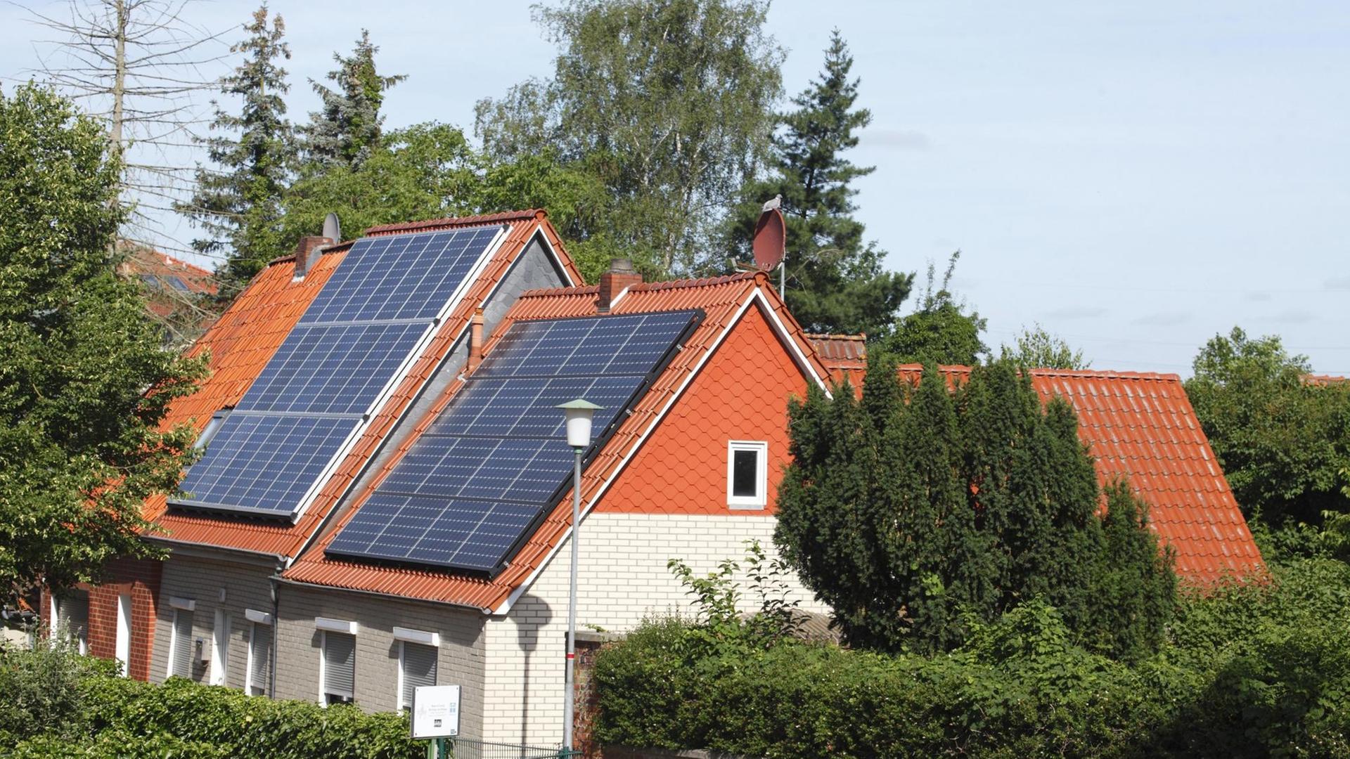 Ein Wohngebäude mit Solarpanel auf dem Dach.