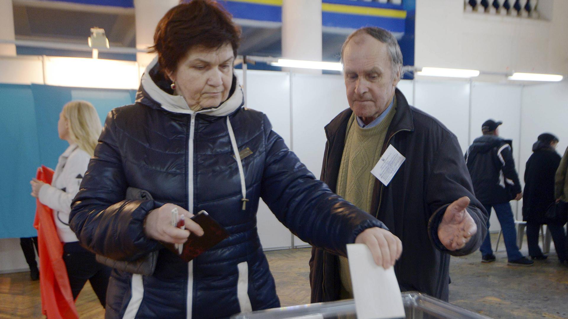 Wähler geben in einem Wahllokal in Sevastopol ihre Stimme ab: Sie werfen die Wahlumschläge in eine durchsichtige Urne.