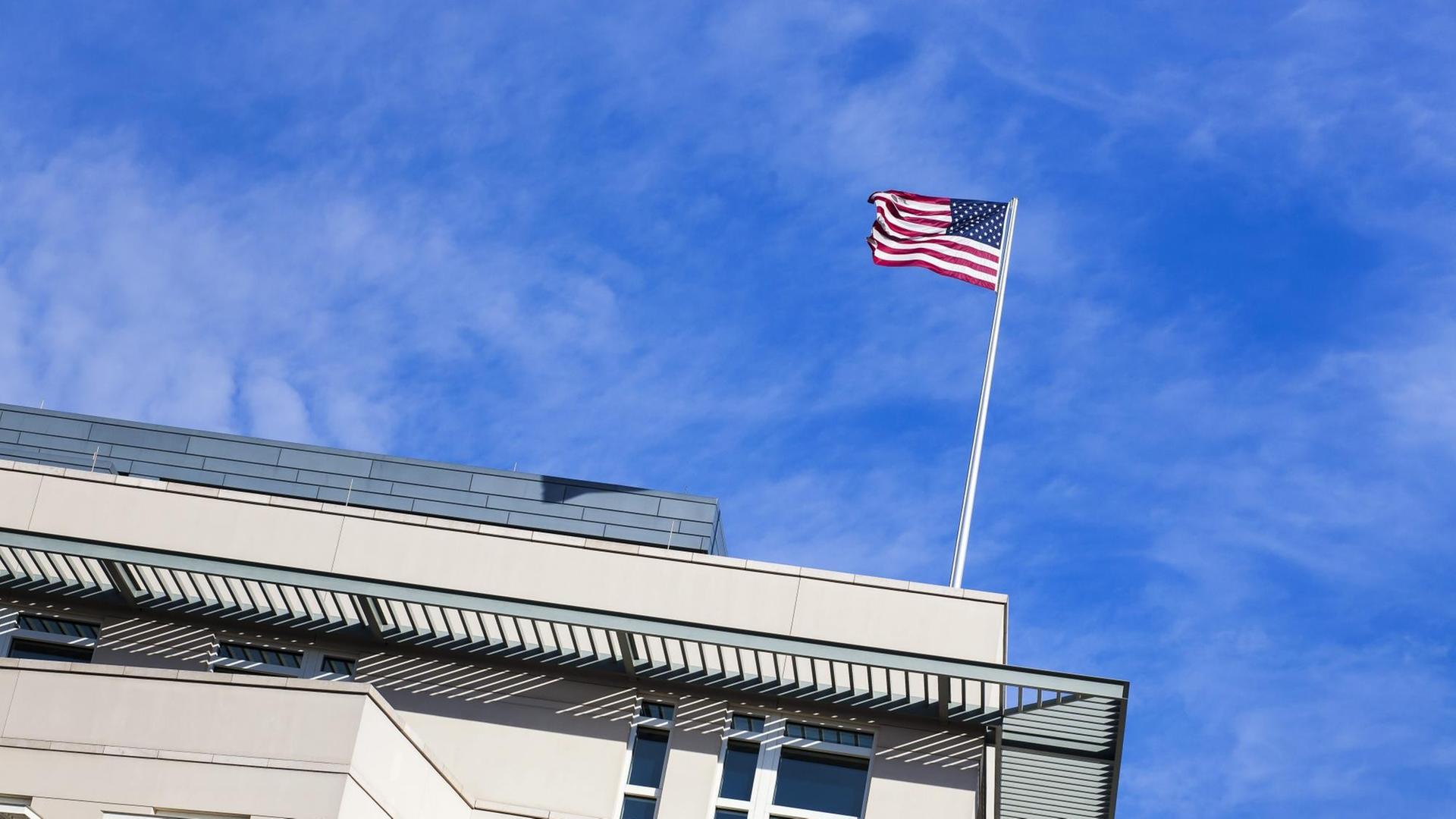 Auf einem Gebäude ist eine USA-Fahne, die im Wind weht.