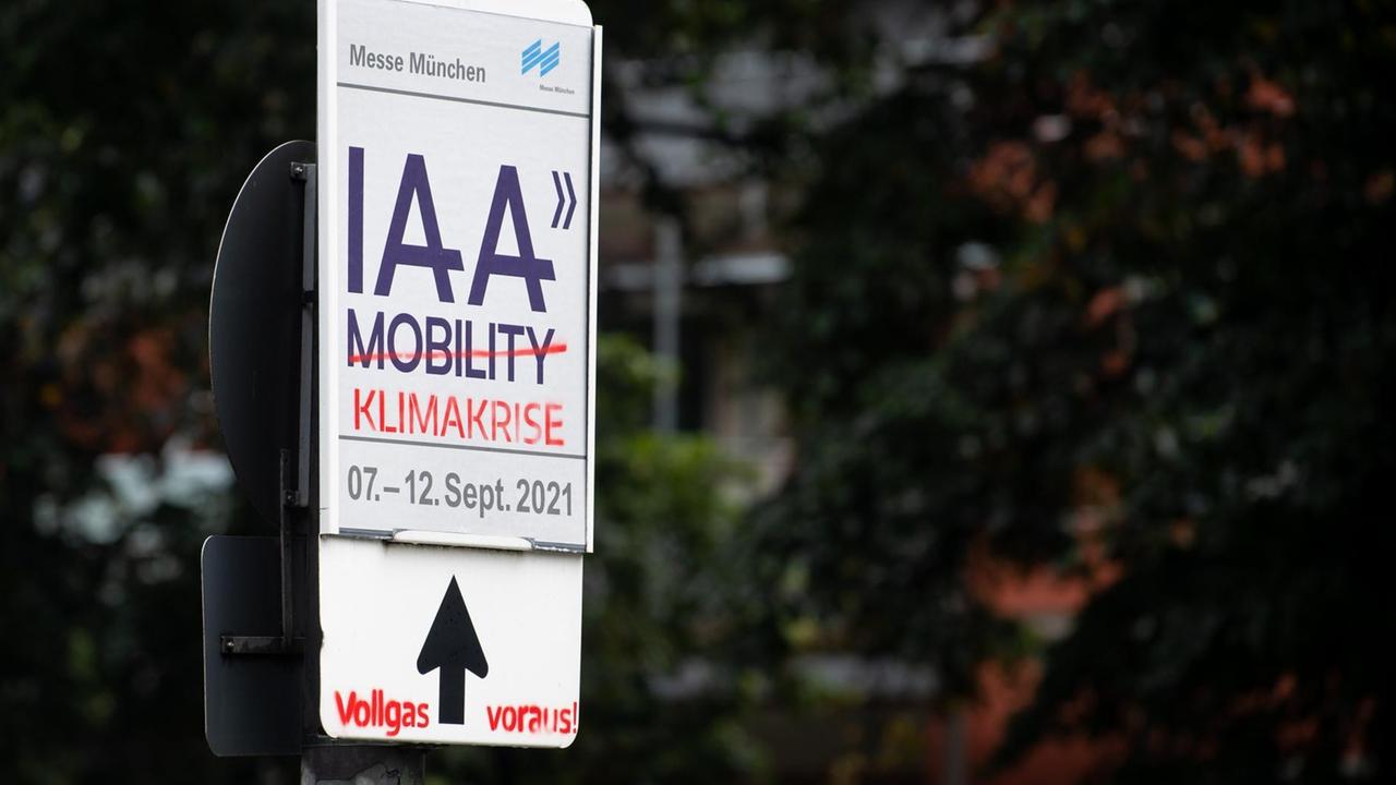 Gegner der Automesse IAA Mobility haben ein Schild mit der Aufschrift "IAA Mobility" mit dem Zusatz "Klimakrise - Vollgas voraus!" übersprüht