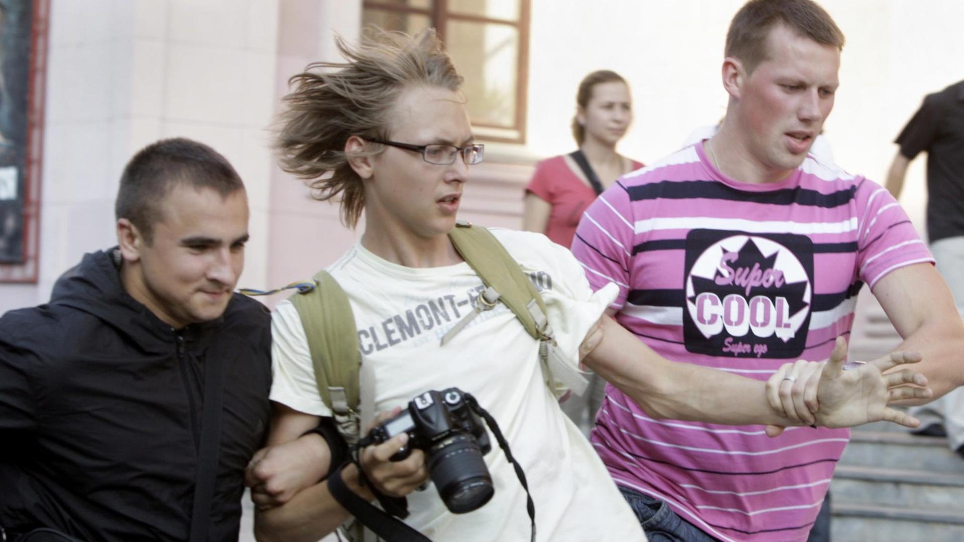 zwei Polizisten in Zivil führen einen Fotojournalisten ab, während einer Protestkundgebung Plain clothed Belarussian policemen detain a press photographer (C) in central Minsk, Belarus, 20 July 2011, when covering a protest against the regime of Belarussian President Lukashenko. Dozens of participants were detained during the protest called 'Revolution via social network'. EPA/TATYANA ZENKOVICH |
