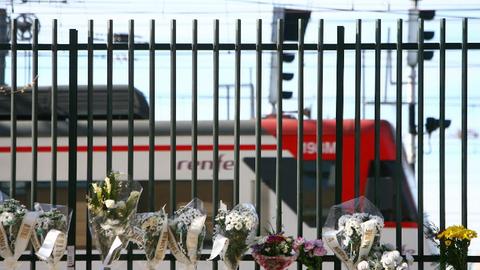 Blumen stecken im Zaun vor der Gleisanlage des Madrider Bahnhofes in Gedenken an die Opfer des Terroranschlages 2004.