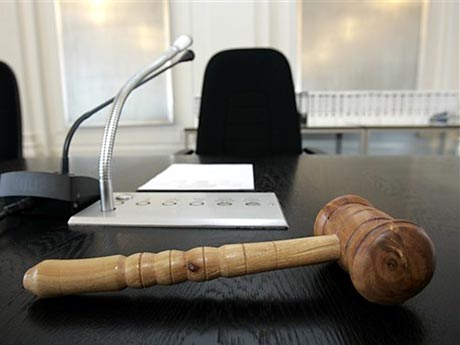 Ein hölzerner Hammer liegt auf dem Platz des Vorsitzenden Richters im Landgericht in Karlsruhe.