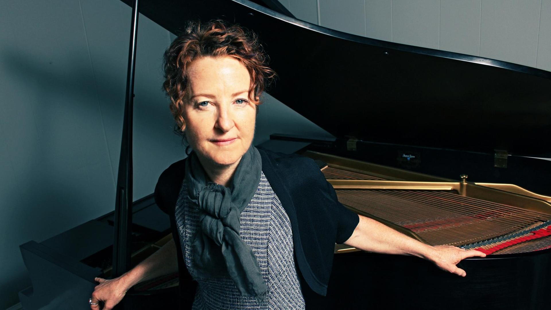 Die Pianistin Myra Melford steht vor ihrem Flügel.