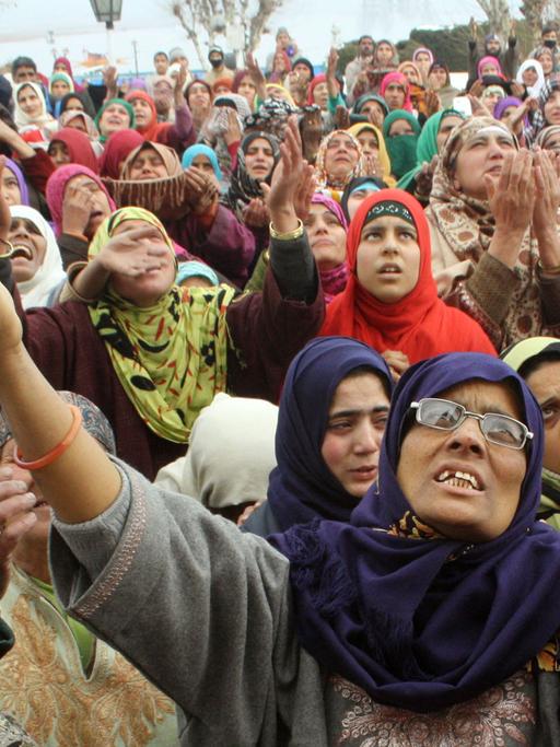 Frauen strecken ihre Arme gen Himmel: Muslime im indischen Kaschmir feiern am Hazratbal-Schrein in Srinagar den Geburtstag des Propheten Mohammed am 14.01.2014