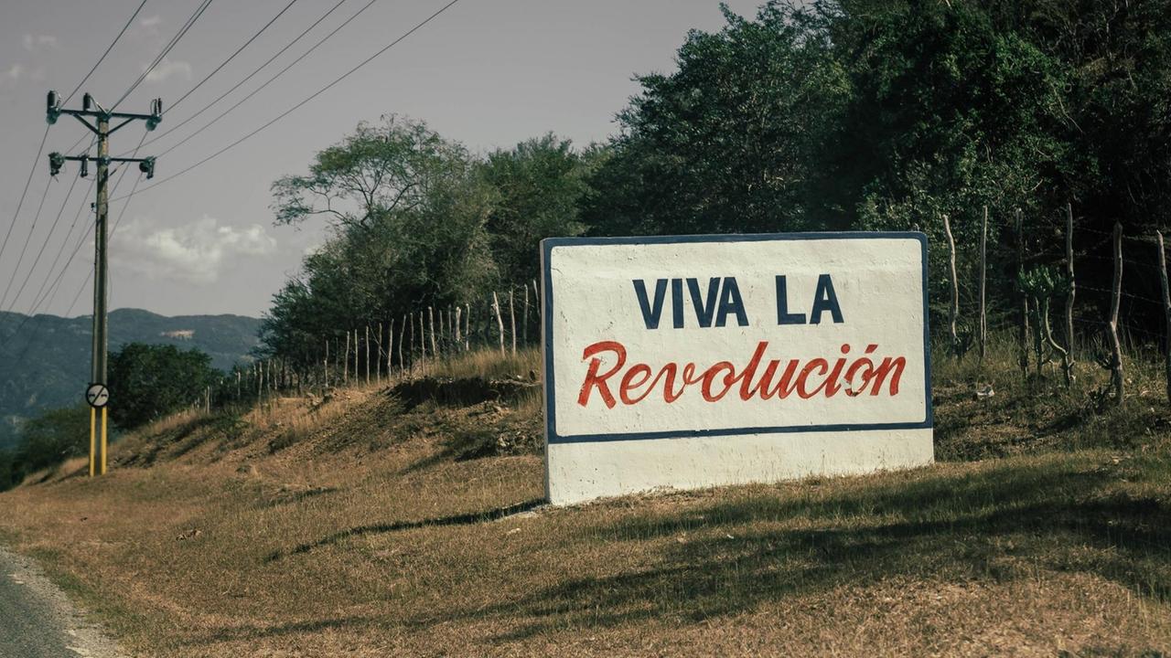 Ein Plakat am Rand einer Landstraße mit der Aufschrift "Viva la Revolución" ("Es lebe die Revolution").