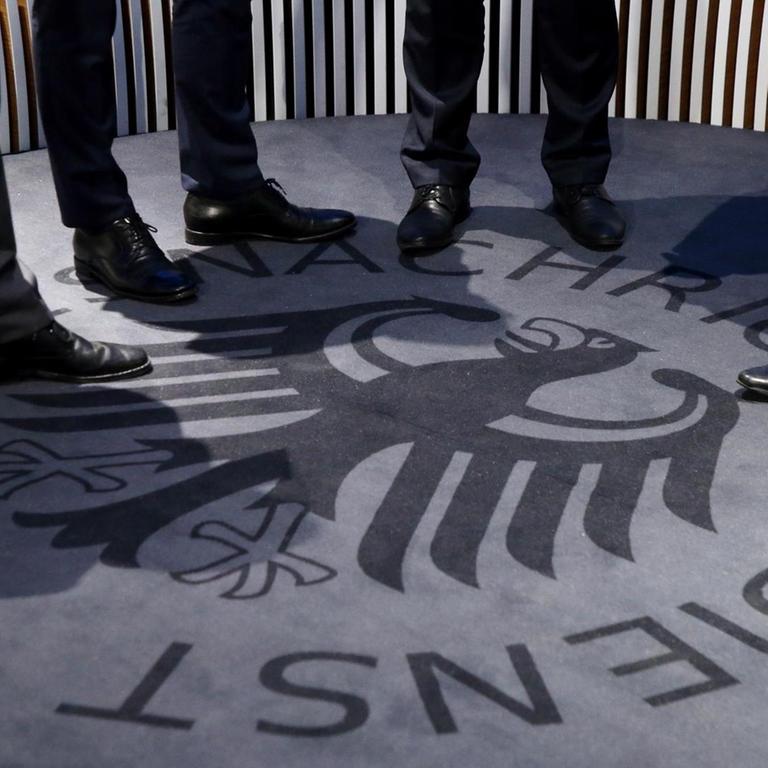 Bei der Eröffnung des Besucherzentrums des BND sind Füße auf dem Logo zu sehen.