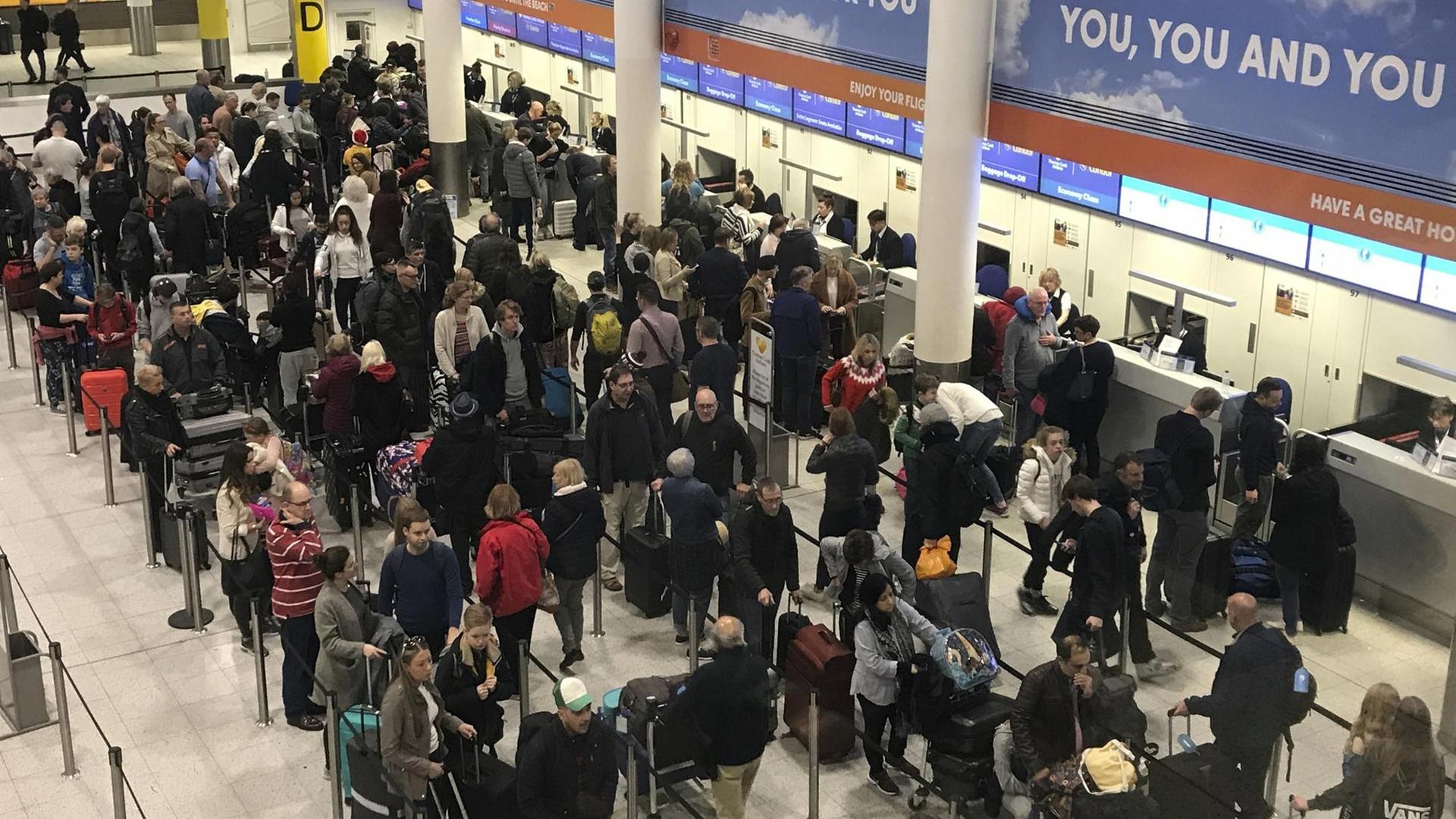 Das Bild zeigt Passagiere in einer Halle des Flughafens London-Gatwick. Sie warten vor den Schaltern. Das Bild zeigt Passagiere in einer Halle des Flughafens London-Gatwick. Sie warten vor den Schaltern.