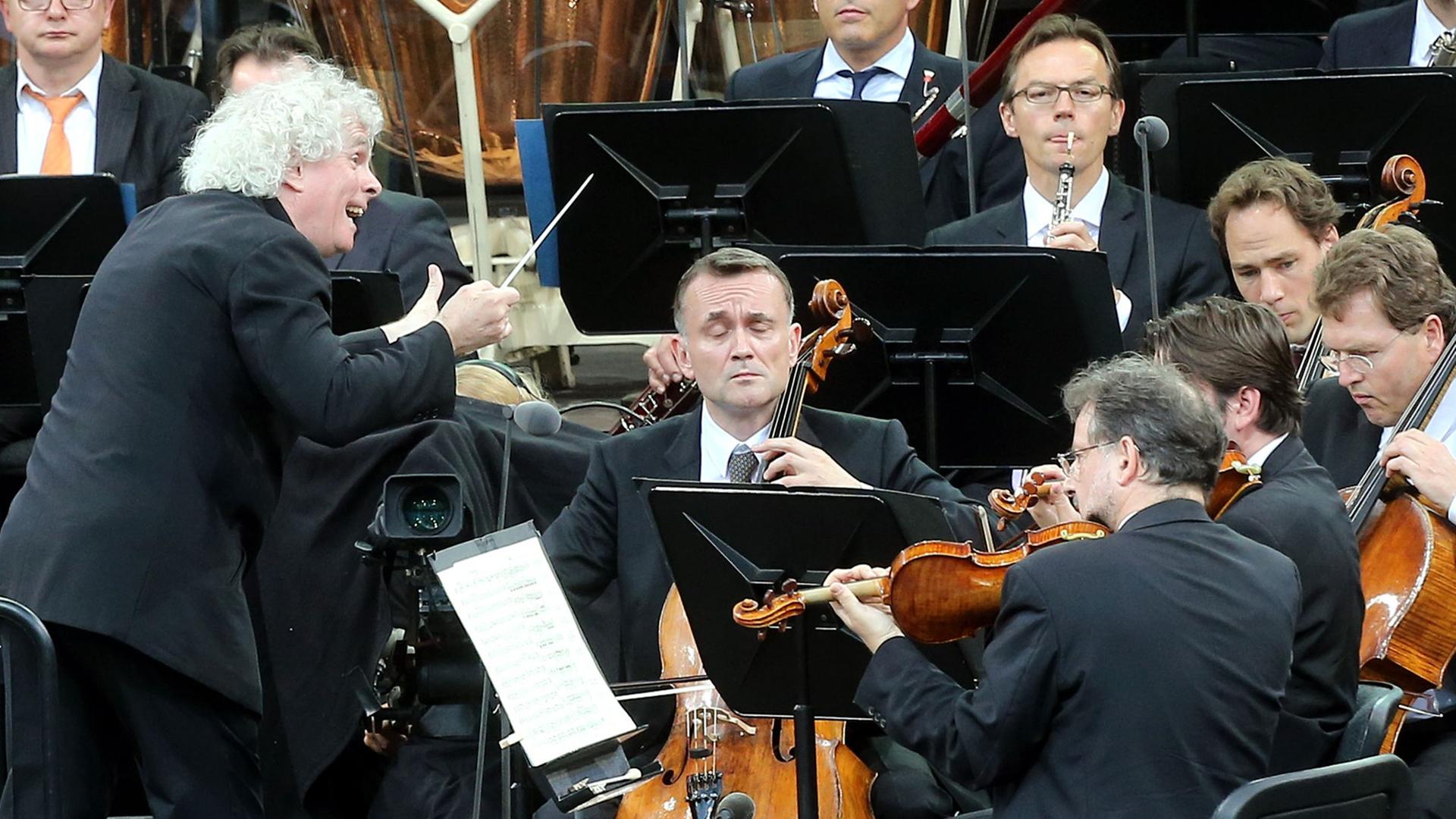 Sir Simon Rattle (l) dirigiert in Berlin das Waldbühnen-Konzert der Berliner Philharmoniker .