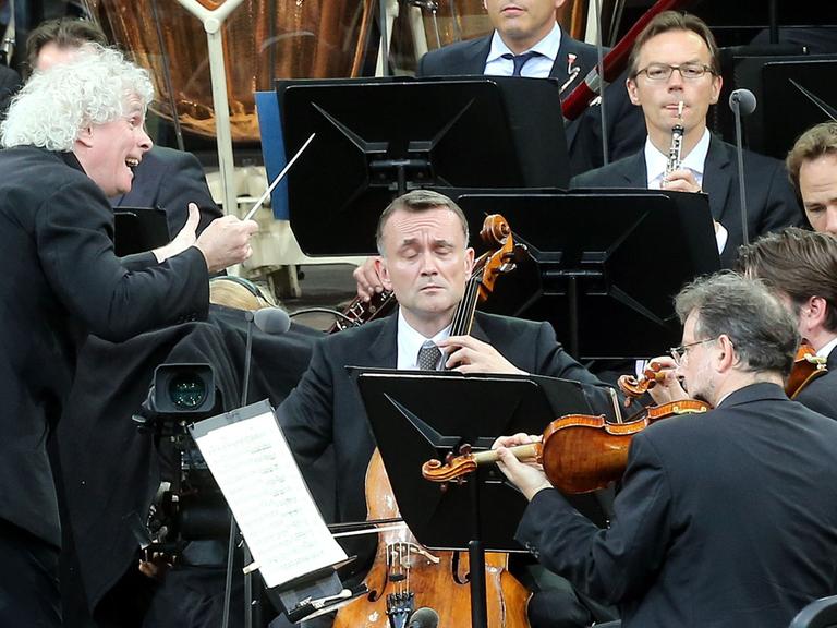 Sir Simon Rattle (l) dirigiert in Berlin das Waldbühnen-Konzert der Berliner Philharmoniker .