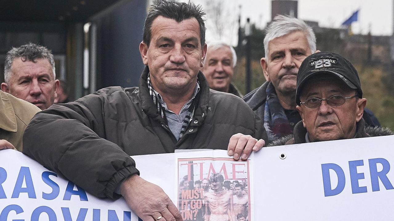 Fikret Alic, hier 2017 vor dem Internationalen Strafgerichtshof für das ehemalige Jugoslawien, mit einem "TIME"-Coverfoto, das ihn als Gefangenen in einem serbischen Lager zeigt