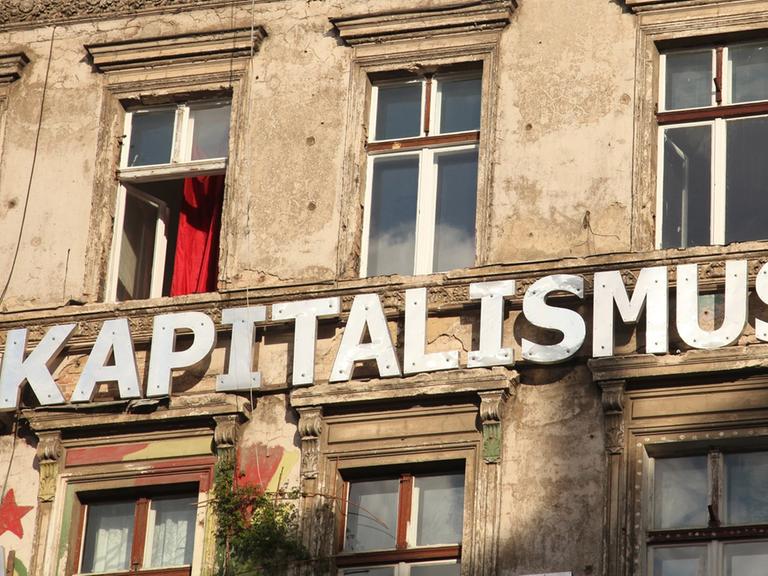 "Kapitalismus" steht auf einer Wand an einem besetzten Haus in einer Straße in Berlin im Stadtteil Prenzlauer Berg , aufgenommen am 11. August 2012.