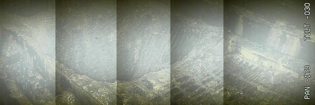 Grobköringes Bild aus einem zerstörten Reaktor in Fukushima. In der Mitte ein Loch. Überall ist geschmolzene Masse zu sehen.