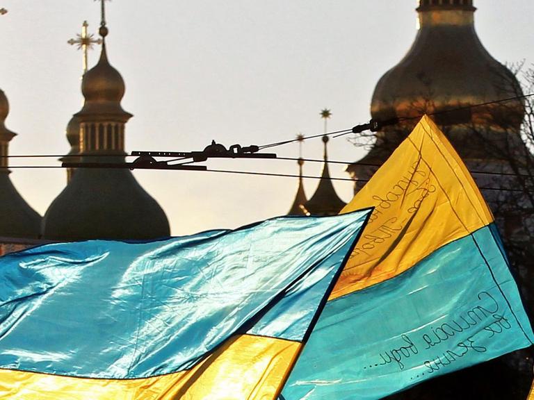 Menschen schwenken Ukraine-Fahnen auf dem Maidan in Kiew.