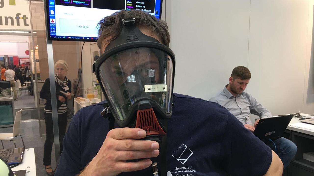 Dr. Rigo Herold, Professor für Digitale Systeme an der Westsächsische Hochschule Zwickau präsentiert auf der Hannover Messe 2019 eine  Feuerwehrmaske mit Datenbrille