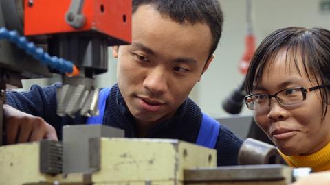 Zwei vietnamesische Arbeiter bei ihrer Ausbildung zu Mechatronikern in Chemnitz - Deutschland bleibt bei Zuwanderern beliebt.