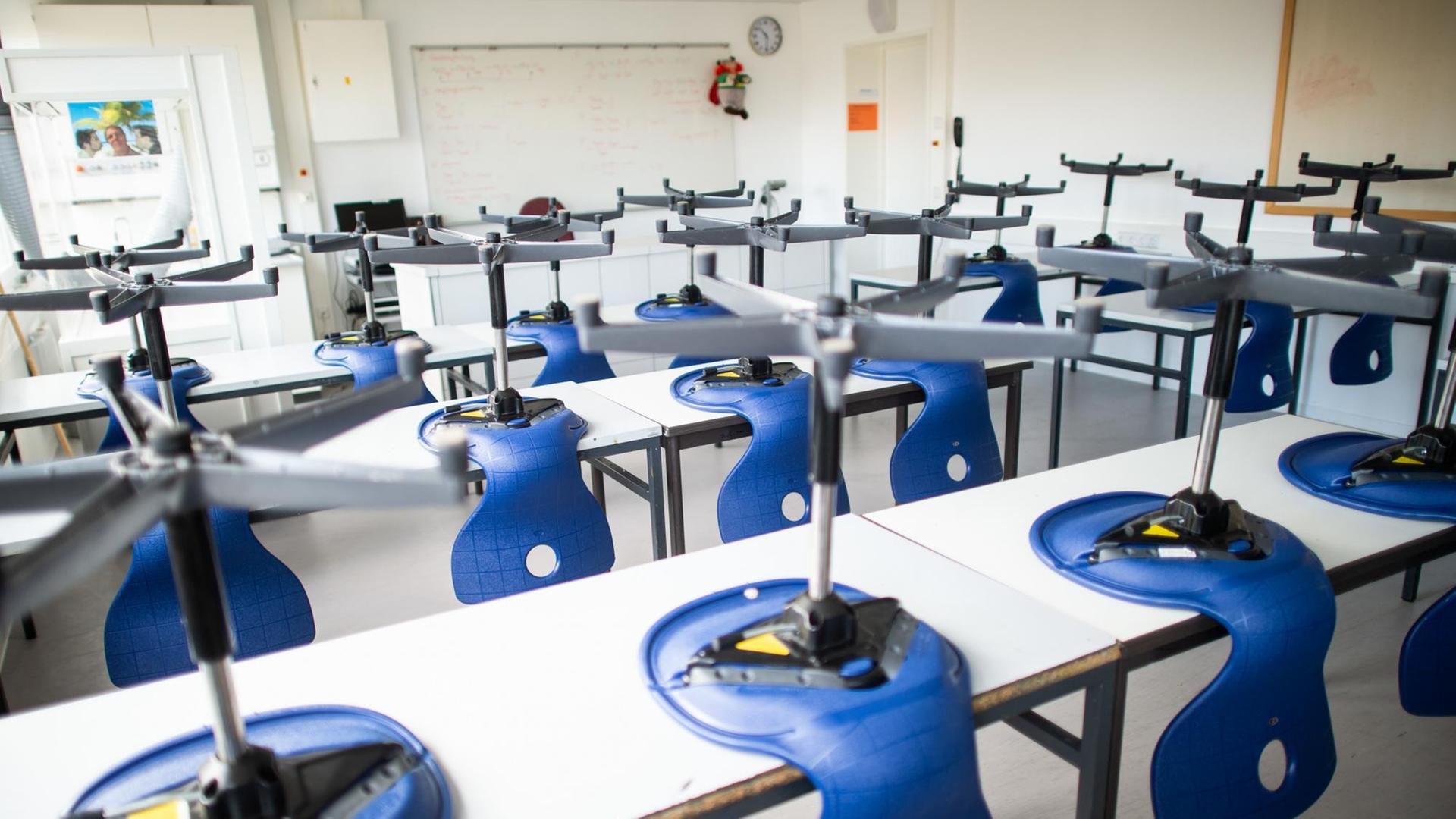 Stühle stehen in einem leeren Klassenzimmer im Carolus-Magnus-Gymnasium auf den Tischen.