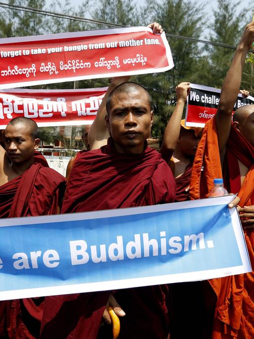 Buddhistische Mönche halten auf einer Demonstration Plakate hoch. Auf einem ist geschrieben "We ar Buddhism."