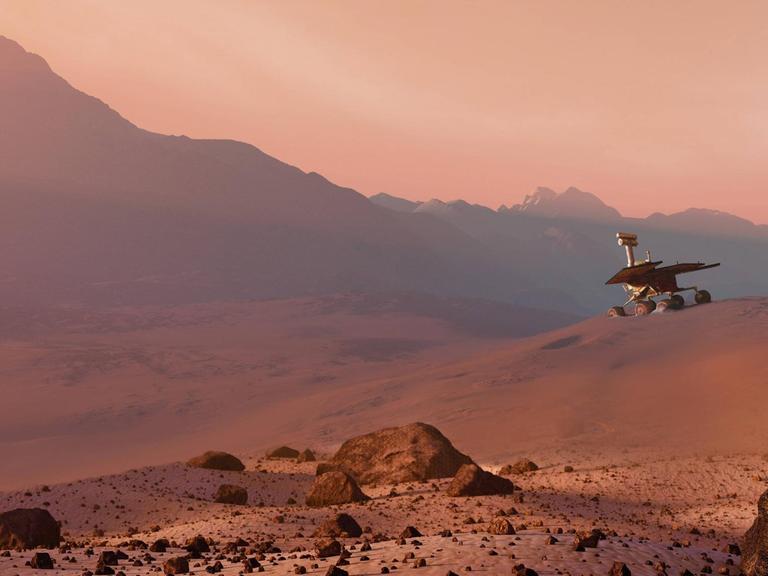 Ein Marsrover in einer hügeligen, rötlichen Landschaft.