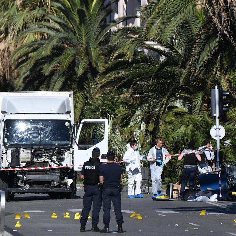 Ermittler stehen neben dem LKW in Nizza, den ein Mann Donnerstag Abend in die Menschenmenge gelenkt hat