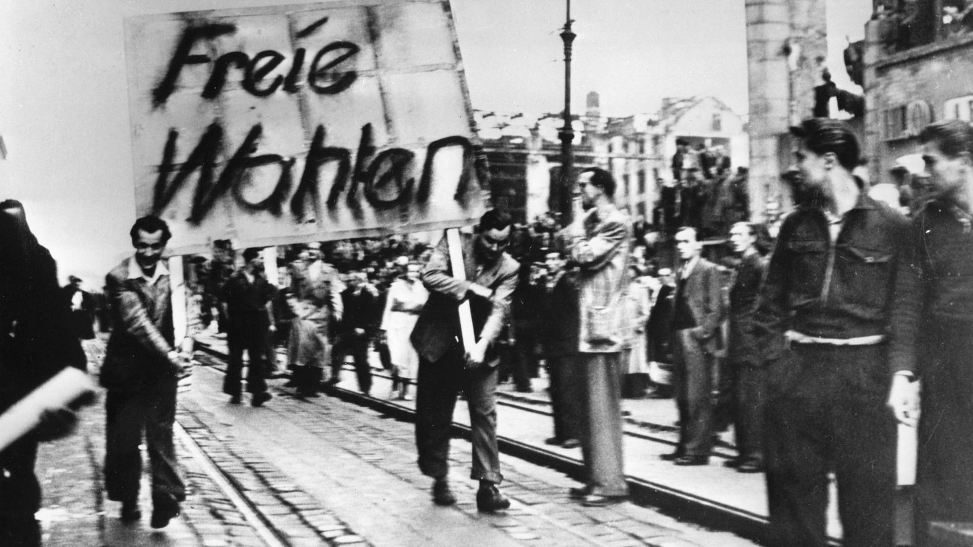 Demonstranten tragen ein Plakat mit der Aufschrift "Freie Wahlen" durch Ostberlin.