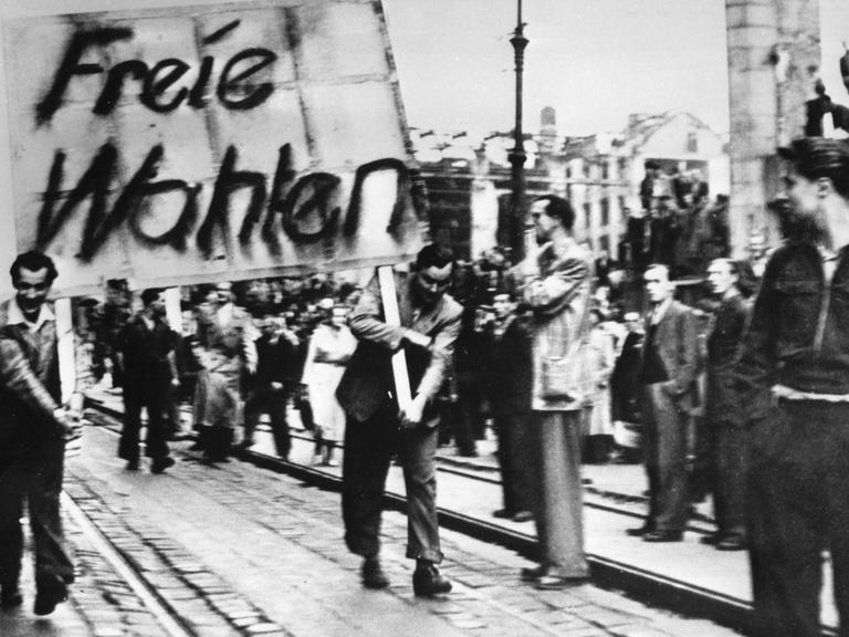 Demonstranten tragen ein Plakat mit der Aufschrift "Freie Wahlen" durch Ostberlin.