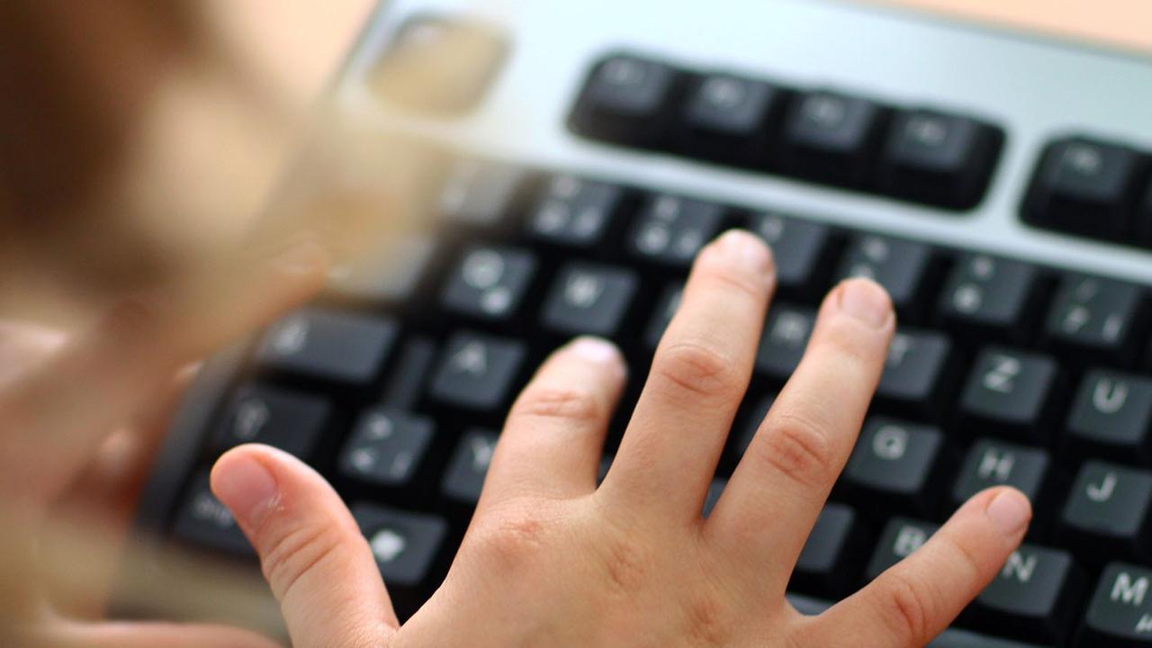 Eine Hand auf einer Computertastatur