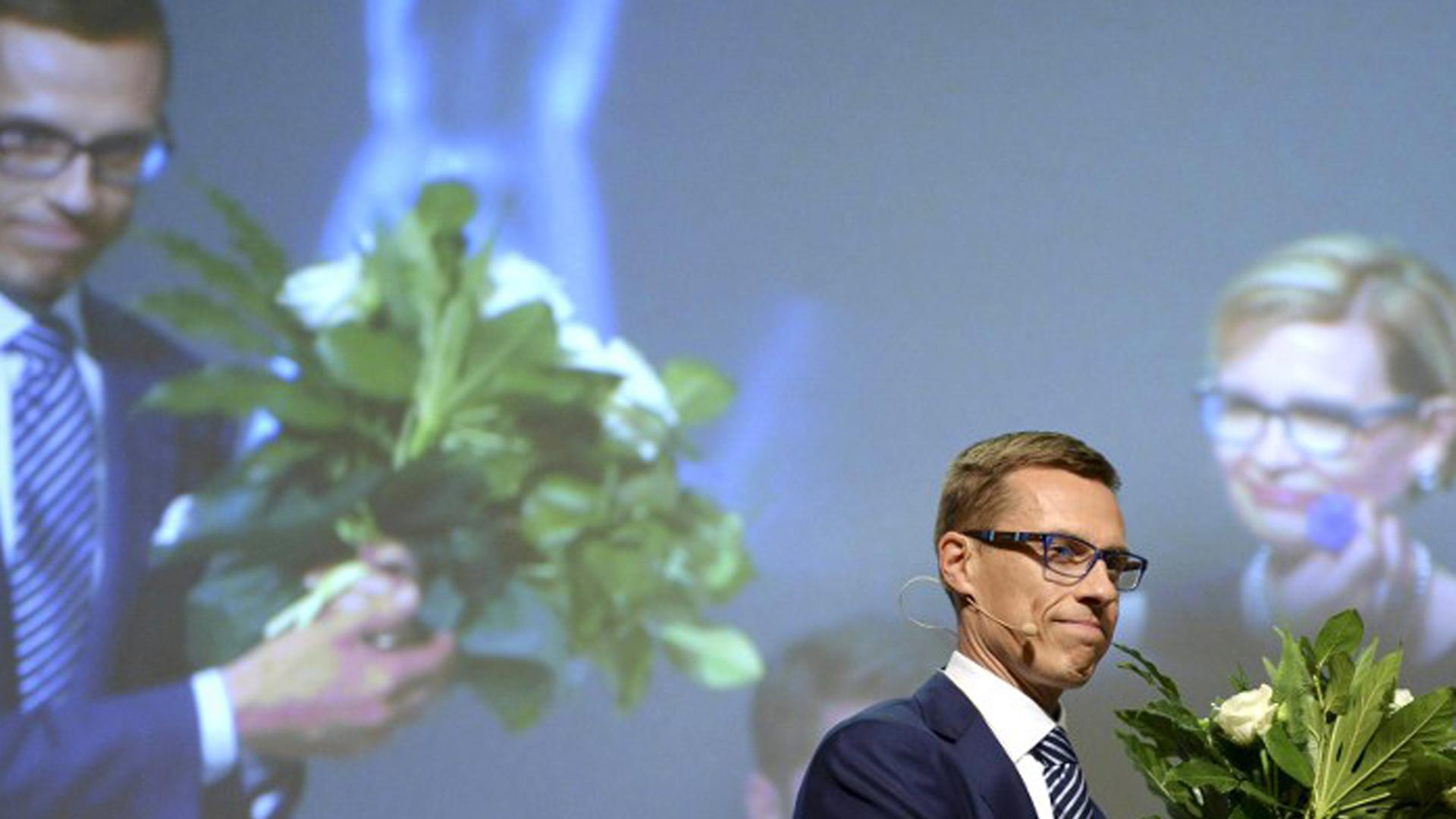 Alexander Stubb steht auf einer Bühne mit Blumenstrauß nachdem ihn die Konservativen in geheimer Wahl zu ihrem neuen Parteichef gekürt haben. Alexander Stubb steht auf einer Bühne mit Blumenstrauß nachdem ihn die Konservativen in geheimer Wahl zu ihrem neuen Parteichef gekürt haben.