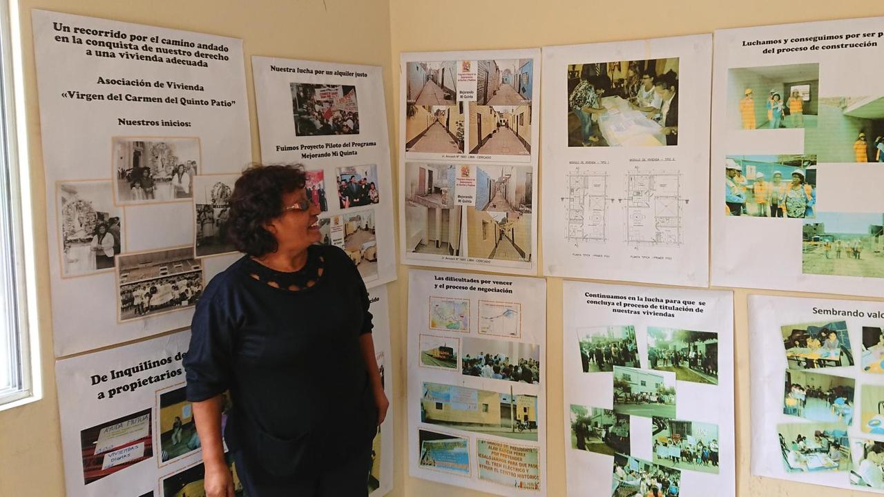 Margarita Monforte mit Bildern in ihrem Wohnzimmer vom Kampf und Bau der neuen Siedlung in Lima.