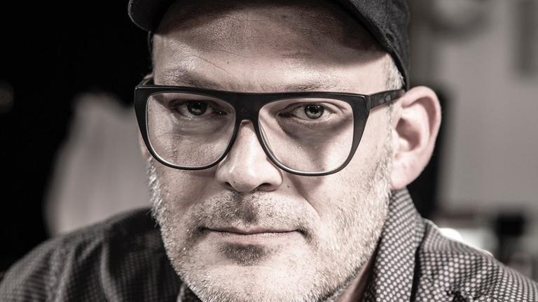 Porträt von Dominik Günther mit Brille und schwarzem Basecap.