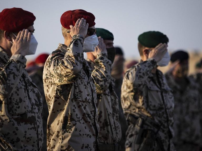 In Afghanistan salutieren Bundeswehrsoldaten in einer Reihe.