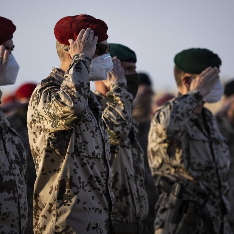 In Afghanistan salutieren Bundeswehrsoldaten in einer Reihe. 