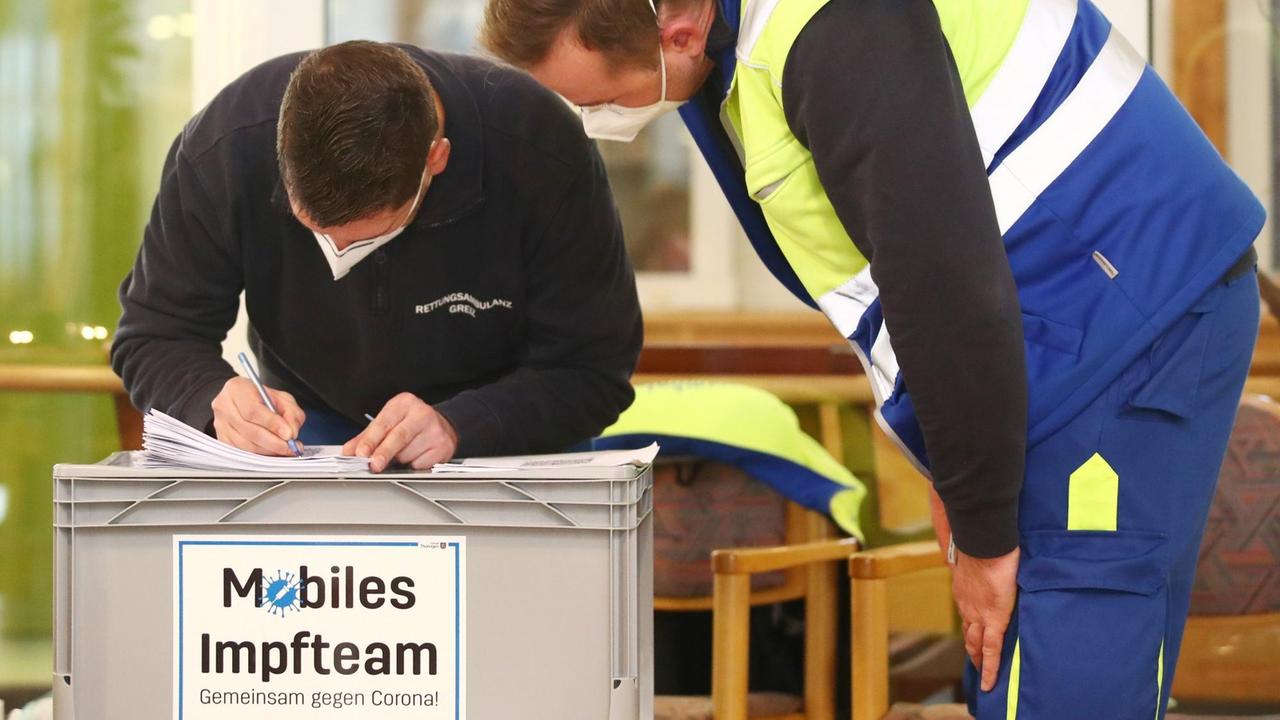 Mitarbeiter eines mobilen Impfteams bereiten die Corona-Impfungen im Seniorenpark Am Birkenwäldchen vor. 