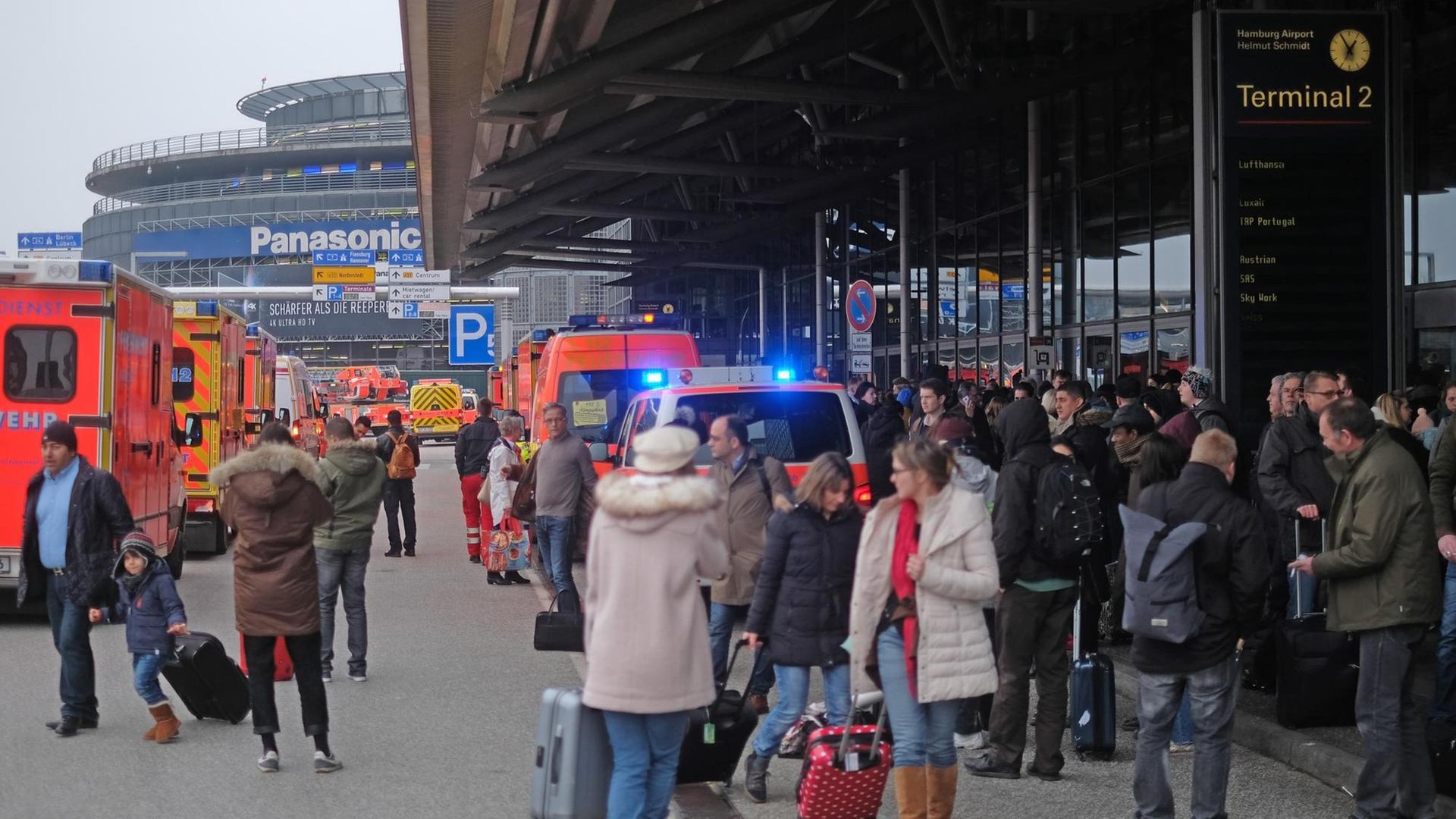 eisegäste verlassen die Terminals des Helmut Schmidt Airports in Hamburg zwischen Fahrzeugen der Einsatzkräfte.