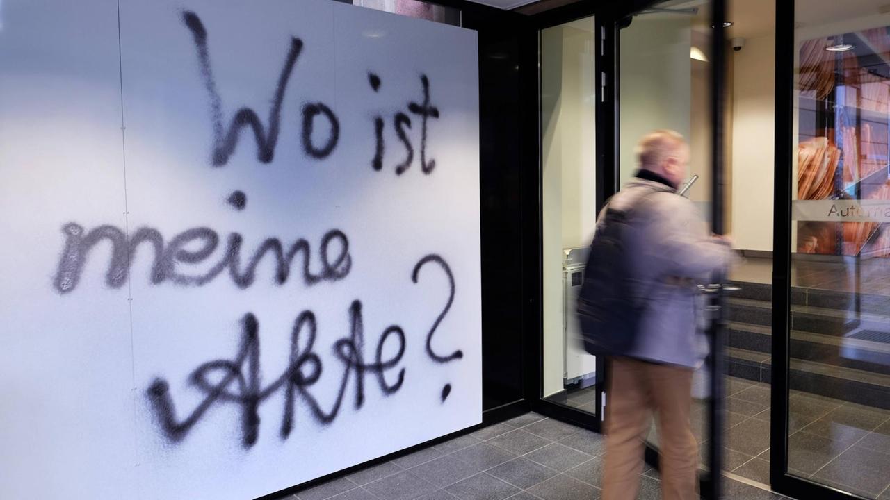 Ein Besucher beim "Tag der Archive" in der ehemaligen Zentrale des Ministeriums für Staatssicherheit (MfS) der DDR in Berlin-Lichtenberg betritt das Gebäude. An der Wand im Eingang steht ein Graffiti: "Wo ist meine Akte?", 2020.