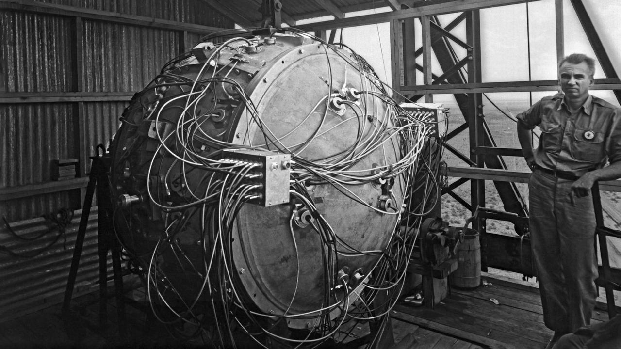 Die "Trinity"-Testbombe mit dem Spitznamen "The Gadget" hängt noch nicht vollständig aufgebaut im Test-Turm, daneben der US-Physiker Norris Bradbury (Juli 1945)