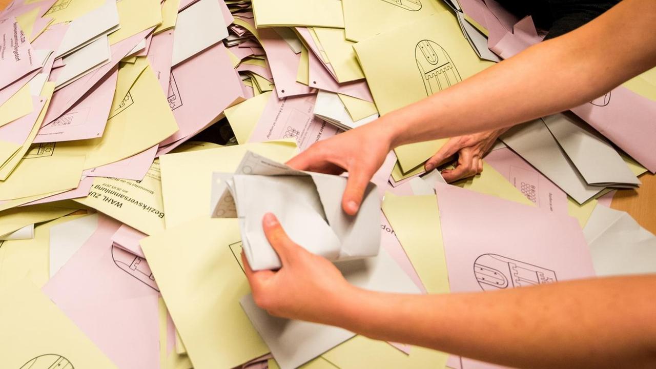 Eine Wahlhelferin leert in einem Wahllokal für die Stimmauszählung die Wahlurne mit den Stimmzetteln zur Wahl in Hamburg.