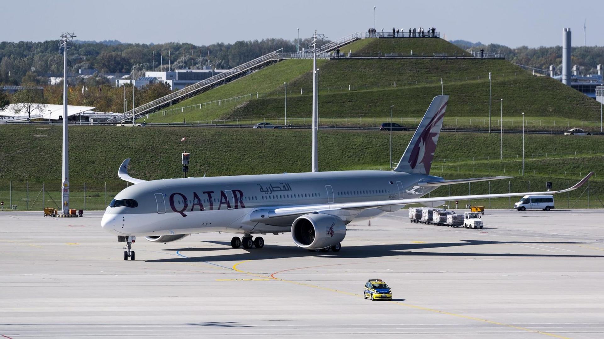 Ein Airbus A350 XWB der Qatar Airways rollt auf einem Flughafen-Rollfeld.