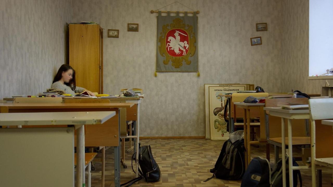 Gewöhnliche Zimmer werden zu Klassenzimmern umfunktioniert. An der Wand hängt ein rotes Wappen, das Anfang der 90er Jahre das Nationalsymbol von Belarus war, danach aber ersetzt wurde die eine Anlehnung an das Wappen aus Sowjetzeiten.