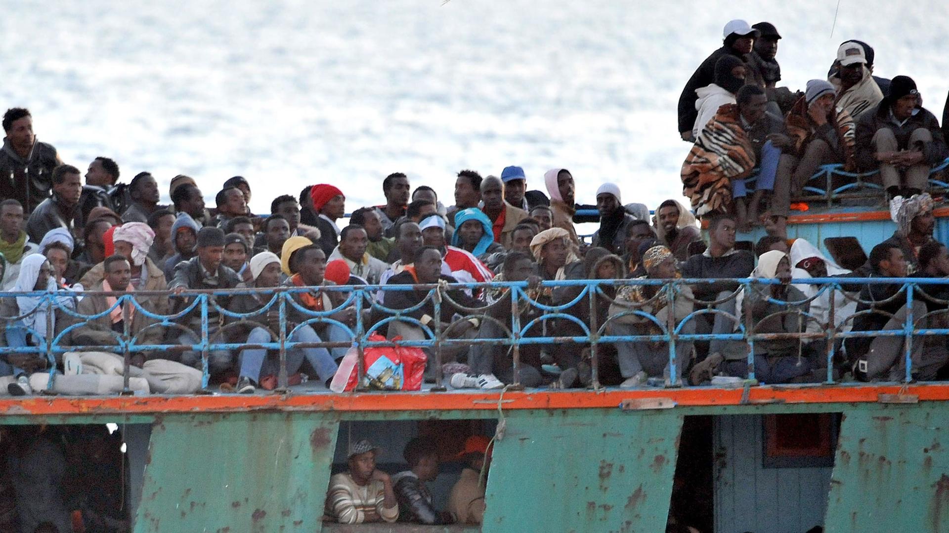 Ein überfülltes Boot mit Flüchtlingen aus Afrika schwimmt vor der italienischen Insel Lampedusa.