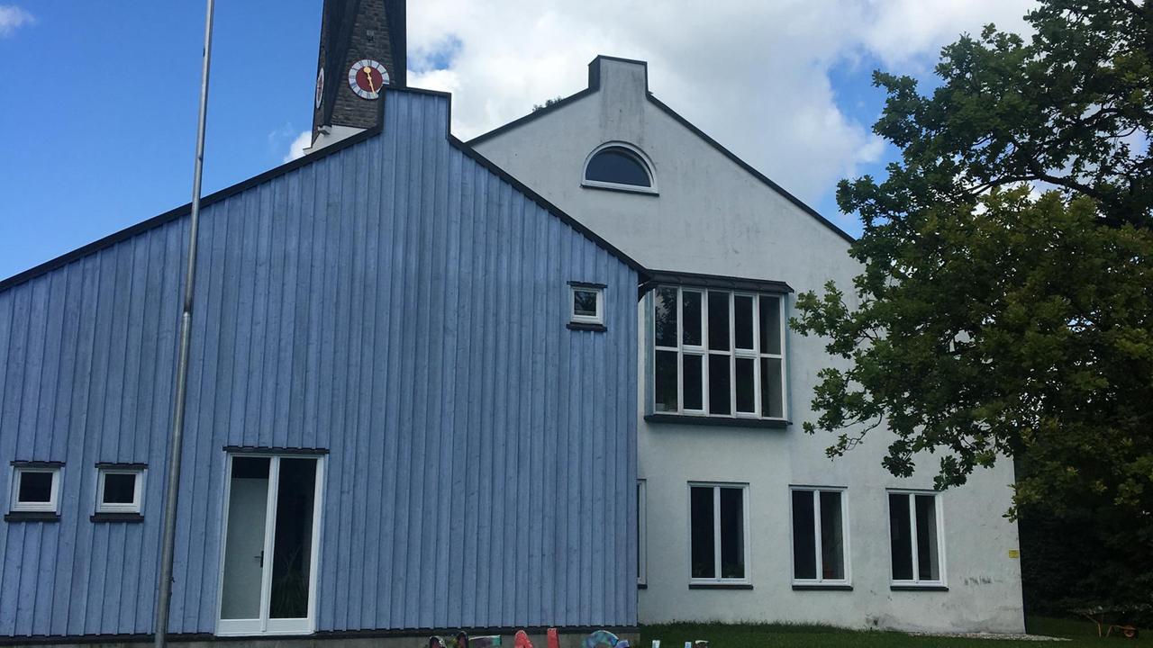 Das Gemeindehaus der evangelischen Gemeinde in Immenstadt ist weiß, ein Anbau ist blau.